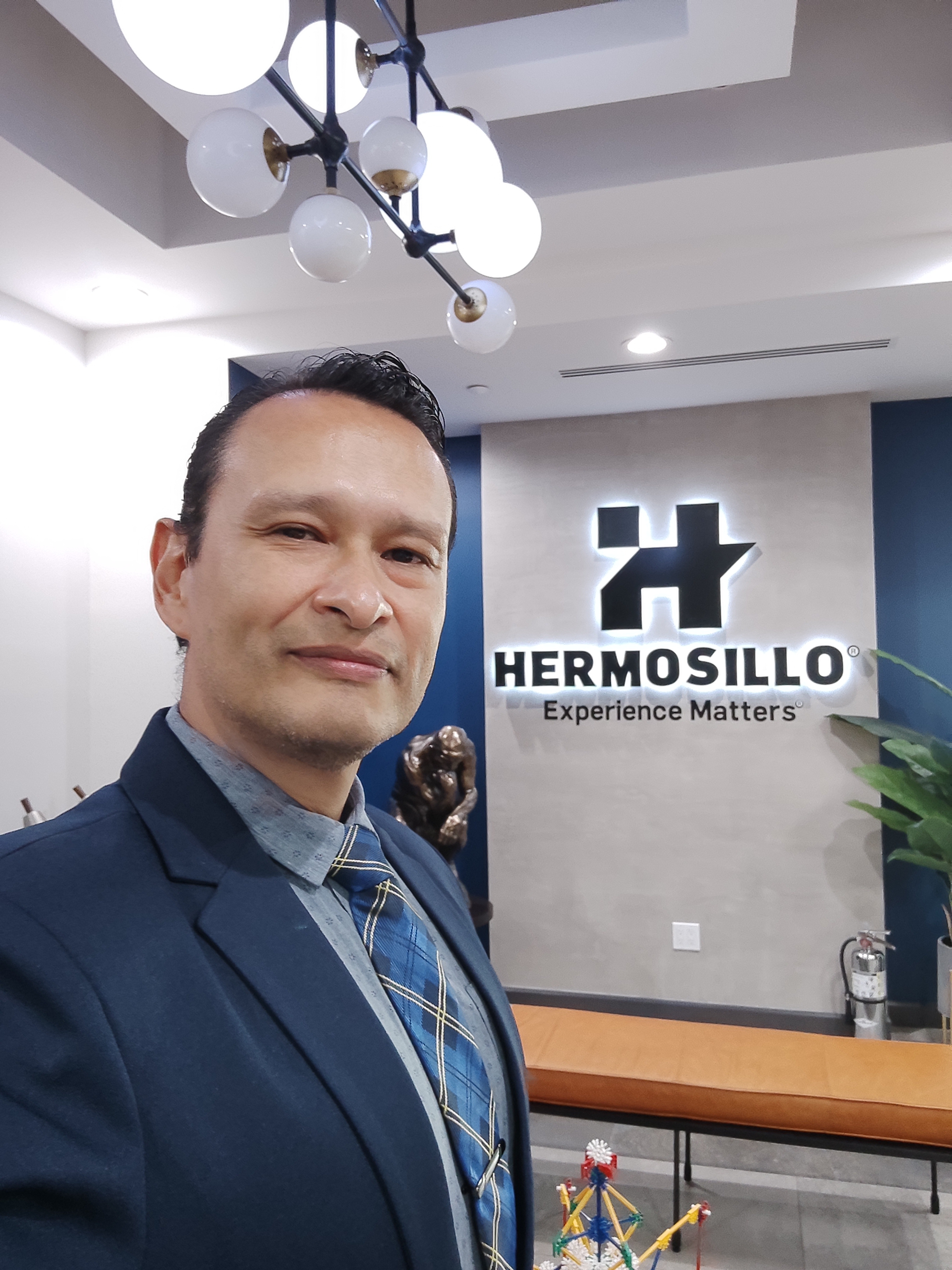 Gustavo Carreño frente al logo de Grupo Hermosillo