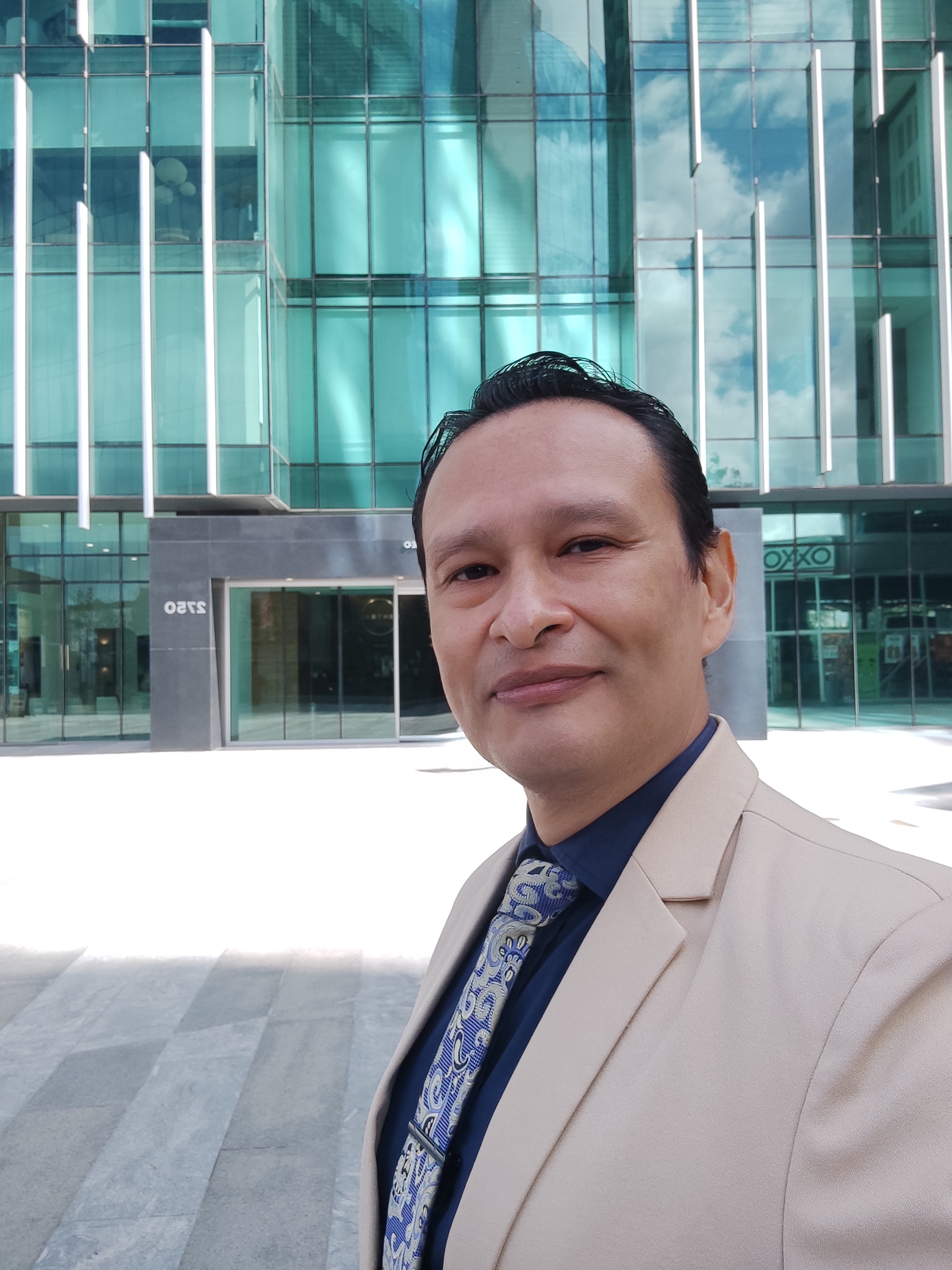 Ejecutivo en Tijuana frente a edificio de vidrio